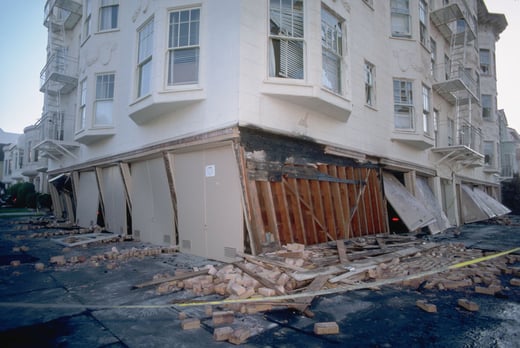Damage to a soft story apartment building's first floor in San Francisco after the Loma Prieta earthquake of 1989.  Photo shows a heavily damaged and partially collapsed first floor with rubble on the ground. 